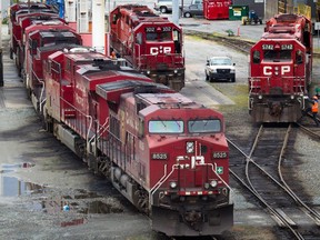 A Canadian Pacific Rail maintenance worker climbs onto a locomotive at the company's Port Coquitlam yard east of Vancouver, B.C., on May 23, 2012.
