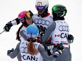 Canada's Trevor Philp of Calgary, top, Candace Crawford, left, Erin Mielzynski, bottom, and Phil Brown celebrate a silver medal during the mixed worlds team skiing event at the alpine skiing world championships on Tuesday in Vail, Colorado.