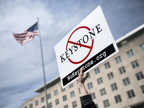 An activist holds up a sign outside the State Department during a protest of the Keystone XL pipeline.