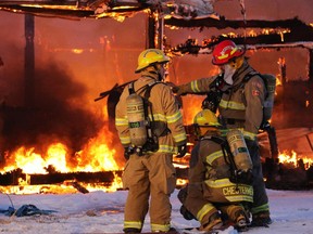 Firefighters deal with a large fire near Balzac northwest of Calgary on Friday evening.