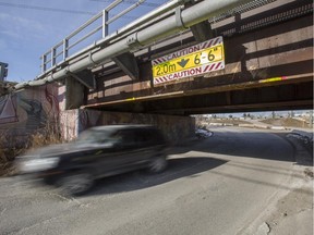 A vehicle passes under the train tracks next to the Elbow River on 7 St. and 9 Ave SE in Calgary, on March 4, 2015.