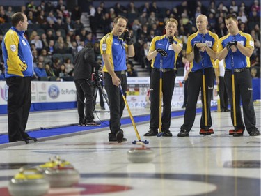 Team Alberta, from left,  coach John Dunn, second Brent Laing, third Marc Kennedy, skip Kevin Koe and lead Ben Hebert, discuss the next best move during a match up against Team Manitoba at the Brier in Calgary, on March 5, 2015.