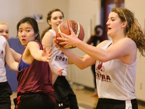 Rundle College Cobra Janna Kwan, centre, reaches out in an attempt to stop a pass to Alyssa Barry during team practice prior to them hosting the 2A girls provincials. Kwan scored the winning basket in the final.