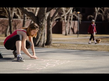 Melissa Paquette chalks a protest against proposed antiterrorism bill C-51 in the centre of the Prince's Island pathway in an attempt to catch attention of passing Calgarians in Calgary on Friday, March 27, 2015.