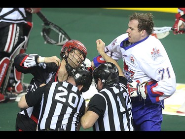 Calgary Roughnecks and Toronto Rock players throw fists during the first period at the Scotiabank Saddledome in Calgary on Saturday, March 28, 2015.