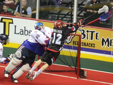 The Calgary Roughneck Sean Pollock, right, sends a leaping shot towards Toronto Rock goaltender Nick Rose at the Scotiabank Saddledome in Calgary on Saturday, March 28, 2015. The Calgary Roughnecks tied Toronto Rock, 5-5, at the half in regular season National Lacrosse League play.