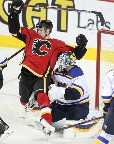 Flames Joe Colborne, left, collides with St. Louis Blues goalie Brian Elliott during their game at the Scotiabank Saddledome.