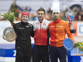 1,500m overall World Cup winner Denny Morrison of Canada, centre, celebrates besides the second placed Sverre Lunde Pedersen of Norway, left, and third placed Kjeld Nuis of Netherlands, right, during the  flower ceremony at the Speedskating World Cup in Erfurt, Germany on Sunday.