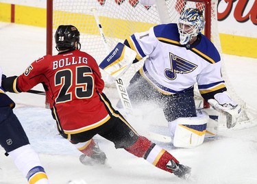 Flames Brandon Bollig, left and St. Louis Blues goalie Brian Elliott during their game at the Scotiabank Saddledome.