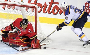 Flames goalie Jonas Hiller, left,  St. Louis Blues Chris Porter during their game at the Scotiabank Saddledome