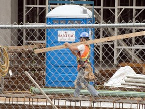 A construction worker carries lumber in Montreal July 2, 2013.