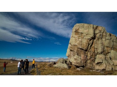 Tourists from the Philippines visit the Big Rock erratic in Okotoks, Alberta on March 19, 2015. The Okotoks glacial erratic, commonly referred to as the Big Rock, was deposited by glaciers traveling from Jasper to its current location in Okotoks, Alberta.