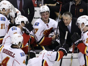 Calgary Flames head coach Bob Hartley sets a play during overtime of an NHL hockey game against the Boston Bruins in Boston, Thursday, March 5, 2015. The Flames defeated the Bruins 4-3 in overtime.