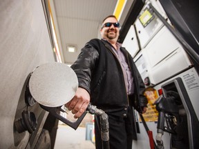 Rob Lamb fuels up before the four-cent surcharge on gas comes into effect in Calgary on Thursday, March 26, 2015.