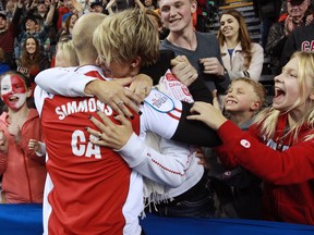 Team Canada's skip Pat Simmons is congratulated by his wife Cindy and family after Team Canada won the 2015 Tim Hortons Brier on Sunday, downing Brad Jacobs' Northern Ontario rink 6-5 in an extra end.