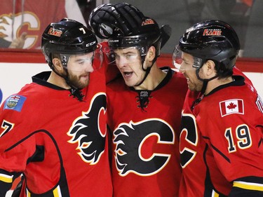 Calgary Flames TJ Brodie, left, and David Jones, right, congratulate Lance Bouma after he scored the third goal against the Colorado Avalanche during the third period of NHL action at the Scotiabank Saddledome Monday March 23, 2015, in this file photo.