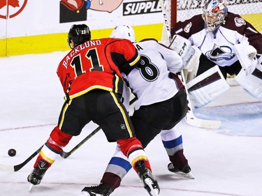 Calgary Flames centre  Mikael Backlund tangles with Colorado Avalanche defenceman Jan Hejda in front of Avalanche goaltender Semyon Varlamov during second period NHL action at the Scotiabank Saddledome Monday March 23, 2015.