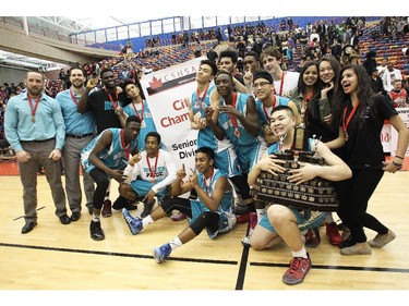 Captain Jairus De Jesus, right, holds the trophy as the Bishop McNally Timberwolves pose for photos after defeating Sir Winston Churchill Bulldogs to win the City High School Division One Basketball Championships Saturday night  March 14, 2015 at the University of Calgary.