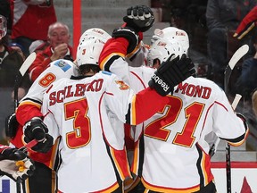 David Schlemko #3, Mason Raymond #21 and Joe Colborne #8 of the Calgary Flames celebrate a third-period goal and the team's third of the game against the Ottawa Senators at Canadian Tire Centre on March 8, 2015 in Ottawa, Ontario, Canada.