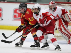 University of Calgary's Jenna Smith, left, battles McGill's Brittany Fouracres during  their quarter-final matchup at the 2015 CIS Women's Hockey Championship held at the Markin MacPhail Centre in Calgary on Thursday.