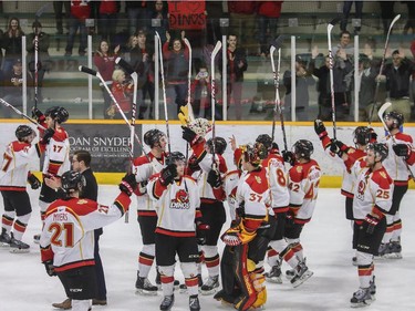 The University of Calgary Dinos raises their sticks in victory after beating the Mount Royal Cougars during CIS playoffs at Father David Bauer arena in Calgary, on March 1, 2015.