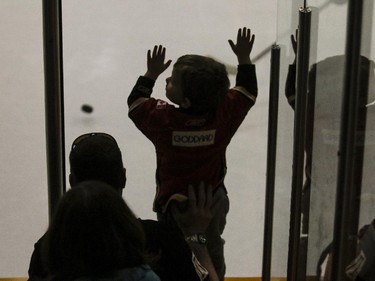 A young fan bangs on the boards and cheers for his team during CIS playoff action between the University of Calgary Dinos and the Mount Royal Cougars at Father David Bauer arena in Calgary, on March 1, 2015.