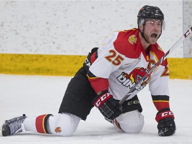 Calgary Dinos' Kevin King dekes out Mount Royal Cougars' goalie Dalyn Flette  to score the first goal of the game during CIS playoff action at Father David Bauer arena in Calgary, on March 1, 2015.