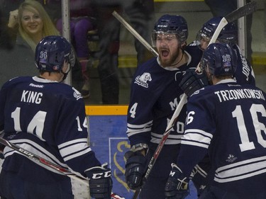 Mount Royal Cougars' Emerson Hrynyk celebrates scoring a goal against the University of Calgary Dinos during CIS playoff action against the at Father David Bauer arena in Calgary, on March 1, 2015.