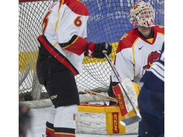 University of Calgary Dinos' goalie Kris Lazaruk reacts after letting in a goal during CIS playoff action against the Mount Royal Cougars at Father David Bauer arena in Calgary, on March 1, 2015.
