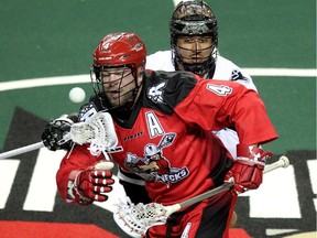 Calgary Roughnecks transition Geoff Snider got tied up with Edmonton Rush transition Jeremy Thompson after a face off during NLL game action at the Scotiabank Saddledome on January 24, 2015.