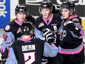 Members of the Calgary Hitmen, clockwise from front left, defenceman Jake Bean, left winger Connor Rankin, centre Adam Tambellini and left winger Jake Virtanen celebrated after Virtanen scored the Hitmen's second goal of the game against the Vancouver Giants during WHL action at the Scotiabank Saddledome on January 25, 2015.