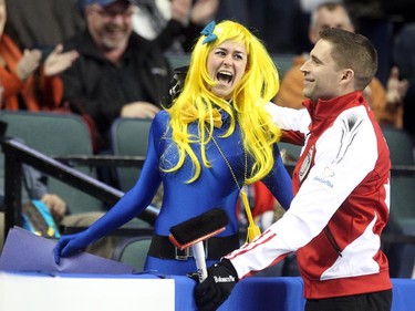 Lac La Biche's Danika Richard, left, reacted after getting a kiss from Team Canada Skip John Morris in between the 6th and 7th ends during the Tim Hortons Brier at the Scotiabank Saddledome on March 1, 2015.