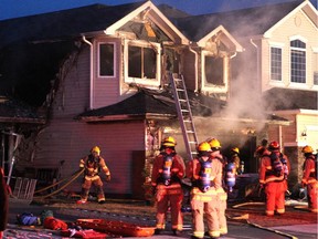 Calgary firefighters worked to ensure the flames were extinguished after a two-alarm house fire on Everridge Drive S.W. on March 10, 2015.