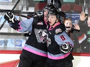 Calgary Hitmen left winger Kenton Helgesen, left, and centre Pavel Karnaukhov celebrate after scoring against the Kootenay Ice  during the second period on Sunday. With a 3-2 triumph, Calgary clinched the Western Hockey League's Central Division title, setting up a first-round playoff date vs. Kootenay for the second-straight year.