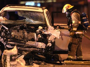 Colleen De Neve/ Calgary Herald CALGARY, AB --MARCH 22, 2015 --Calgary fire fighters worked to dowse the smouldering engine of an SUV which was involved in a collision with a Calgary Transit bus at the intersection of Willow Park Drive and Macleod Trail SW on March 22, 2015. (Colleen De Neve/Calgary Herald) (For City story by Annalise Klingbeil) 00063489A SLUG: 0323-Serious MVA