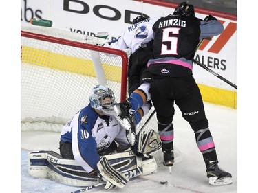 Kootenay Ice goalie Wyatt Hoflin had his mask knocked off as the skate of teammate defenceman Troy Murray got under it as he collided with Calgary Hitmen defenceman Keegan Kanzig during second period WHL action at the Scotiabank Saddledome on March 22, 2015.