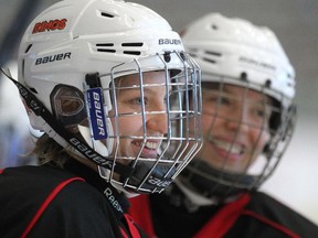 University of Calgary Dinos women's hockey player Iya Gavrilova, left, smiles as she waited for her turn during skating drills with teammates.