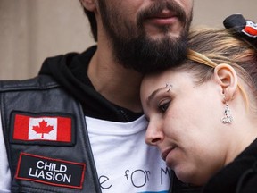 Kyla Woodhouse is comforted by her husband, Bryan Woodhouse outside the courthouse in Calgary on Tuesday, March 24, 2015.