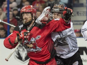 Calgary's Curtis Dickson battles with Edmonton's Kyle Rubisch in National Lacrosse League action on Sunday.
