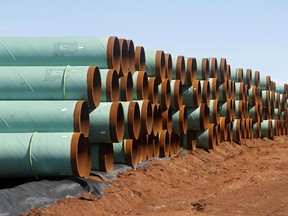 FILE - In this Feb. 1, 2012 file photo, miles of pipe for the stalled Canada-to-Texas Keystone XL pipeline are stacked in a field near Ripley, Okla. The recent surge in oil production, from roughly 5 million barrels a day in 2008 to 8.9 million barrels in 2014, has led to more than 11,600 miles of crude oil pipeline being added to the domestic oil network _ the equivalent of 14 Keystone XL pipelines.