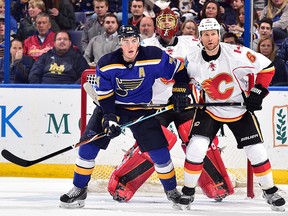 OCTOBER 11: T.J. Oshie #74 of the St. Louis Blues skates against Dennis Wideman #6 of the Calgary Flames