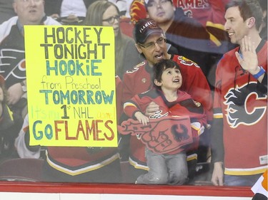 First hockey game and first hookie lesson for one young Flames fan during  the game against the Philadelphia Flyers at the Saddledome in Calgary, on March 19, 2015. It will be worth it since the Flames smokes the Flyers 4-1.