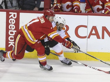 Calgary Flames Mikael Backlung races for the puck against Philadelphia Flyers Chris VandeVelde during NHL action at the Saddledome in Calgary, on March 19, 2015.