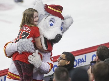 Calgary Flames Harvey the Hound gets a hug from a young Gaudreau fan during third period action against the Philadelphia Flyers at the Saddledome in Calgary, on March 19, 2015.