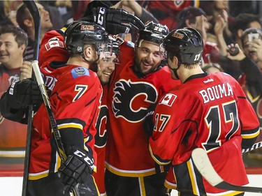 Calgary Flames Tj Brodie, from left, Josh Jooris, Deryk Engelland, and Lance Bouma celebrate after Engelland scores his first goal as a Calgary Flames and ties up the match against the Dallas Stars at the Saddledome in Calgary, on March 25, 2015.