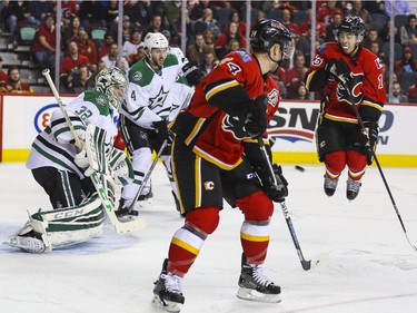 Calgary Flames Johnny Gaudreau, right, attempts to get out of the way of a shot at Dallas Stars goalie Kari Lehtonen during game action at the Saddledome in Calgary, on March 25, 2015.