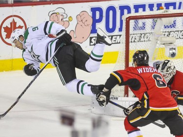 Dallas Stars Jason Spezza gets some air after tripping over Calgary Flames goalie Karri Ramo during game action at the Saddledome in Calgary, on March 25, 2015.