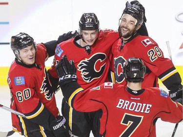 Calgary Flames Markus Granlund, from left, Mason Raymond, Deryk Engelland  and Tj Brodie, celebrate Engelland scores his second goal his Flames career and his second goal of the game, to tie it up a second time against the Dallas Stars at the  Saddledome in Calgary, on March 25, 2015.