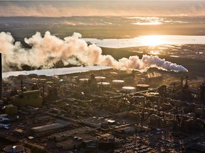 The setting sun reflects off a tailings pond behind Syncrude's oilsands upgrading facility north of Fort McMurray in June 2013.