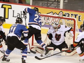 Kootenay Ice right-winger Zak Zborosky, centre, attempts to score on the Hitmen net at the Scotiabank Saddledome on Sunday. Calgary won 3-2 in overtime to tie the series 1-1.
